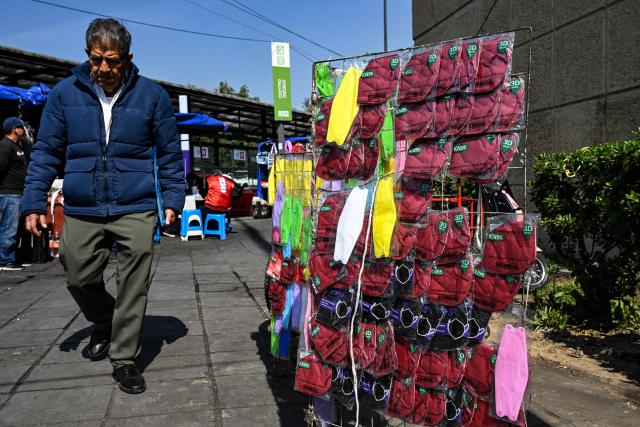 A man walks past a street stall that sells face masks outside Centro Medico Hospital in Mexico City on February 6, 2026. (Photo by Yuri CORTEZ / AFP)