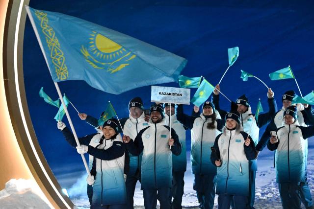 Kazakhstan's flag bearer Ayaulum Amrenova parades with members of the delegation during the Milano Cortina 2026 Winter Olympic Games in Livigno, northern Italy, on February 6, 2026. (Photo by Jeff PACHOUD / AFP)