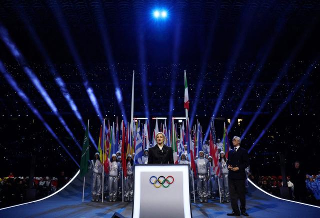 President of the International Olympic Committee (IOC) Kirsty Coventry (C), flnaked by President of the Organising Committee for the 2026 Olympic and Paralympic Winter Games Giovanni Malago (L), delivers a speech during the opening ceremony of the Milano Cortina 2026 Winter Olympic Games at the San Siro stadium in Milan, northern Italy, on February 6, 2026. (Photo by Yves Herman / POOL / AFP)