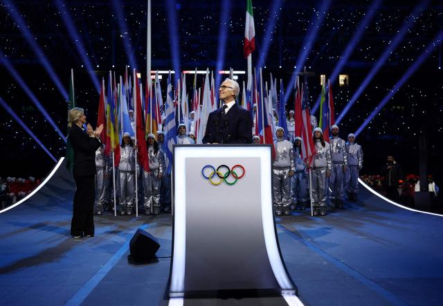 President of the Organising Committee for the 2026 Olympic and Paralympic Winter Games Giovanni Malago (C), flanked by President of the International Olympic Committee (IOC) Kirsty Coventry (R), delivers a speech during the opening ceremony of the Milano Cortina 2026 Winter Olympic Games at the San Siro stadium in Milan, northern Italy, on February 6, 2026. (Photo by Yves Herman / POOL / AFP)