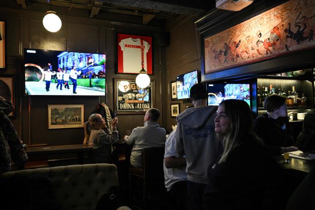 People watch the live TV broadcast of the Milano Cortina 2026 Winter Olympic Games opening ceremony at a bar in central Moscow, on February 6, 2026. (Photo by HECTOR RETAMAL / AFP)