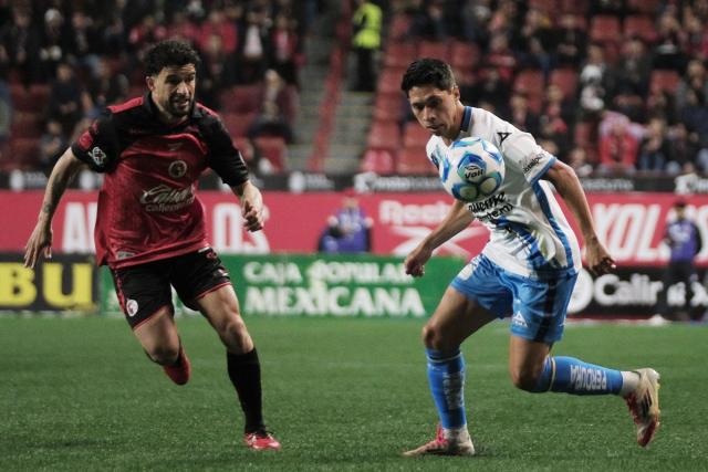 Tijuana's Uruguayan midfielder #22 Ignacio Rivero and Puebla's midfielder #22 Carlos Baltazar fight for the ball during the Liga MX Clausura football match between Tijuana and Puebla at the Caliente Stadium in Tijuana, Mexico, on February 6, 2026. (Photo by Guillermo Arias / AFP)