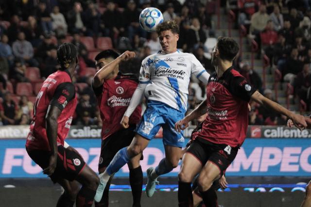 Puebla's midfielder #24 Alejandro Organista heads the ball next to Tijuana's Spanish defender #04 Unai Bilbao during the Liga MX Clausura football match between Tijuana and Puebla at the Caliente Stadium in Tijuana, Mexico, on February 6, 2026. (Photo by Guillermo Arias / AFP)