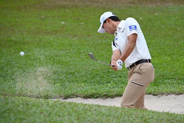 South Korea's Cho Woo-young plays a bunker shot during the third round of the Philippines Golf Championship tournament at the Wack Wack Golf and Country Club in Manila on February 7, 2026. (Photo by Ted ALJIBE / AFP)