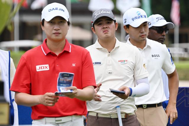 (L-R) South Korea's Wang Jeung-hun, Thailand's Sarut Vongchaisit, and South Korea's Cho Woo-young wait for their turn on the first green during the third round of the Philippines Golf Championship tournament at the Wack Wack Golf and Country Club in Manila on February 7, 2026. (Photo by Ted ALJIBE / AFP)