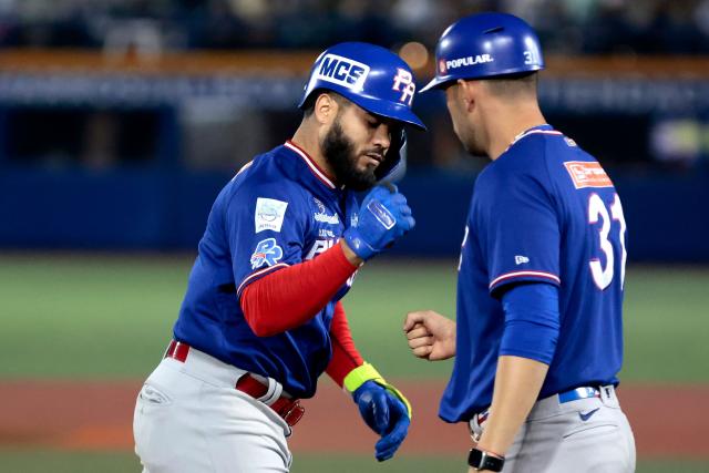 Cangrejeros de Santurce's #1 Gabriel Cancel celebrates with a team staff after hitting a home run in the third inning of the Caribbean Series baseball tournament semi-final game between Mexico's Charros de Jalisco and Puerto Rico's Cangrejeros de Santurce at the Panamerican Stadium in Jalisco, Mexico, on February 6, 2026. (Photo by Ulises Ruiz / AFP)