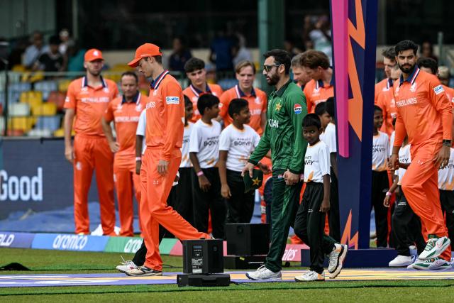 Netherlands' captain Scott Edwards (front L) enter the pitch with his Pakistan counterpart Salman Agha (front 2L) before the start of the 2026 ICC Men's T20 Cricket World Cup group stage match between Pakistan and Netherlands at the Sinhalese Sports Club (SSC) Ground in Colombo on February 7, 2026. (Photo by Ishara S.KODIKARA / AFP)