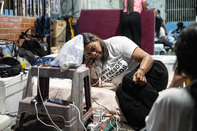 A woman uses her mobile phone as she camps outside El Rodeo I prison as they wait for news of prisoner releases in Guatire, Miranda state, some 30 kilometers east of Caracas, on February 6, 2026. Venezuela's parliament chief, a former member of ousted leader Nicolas Maduro's inner circle, on February 6 promised the speedy release of remaining political prisoners during a meeting with their relatives. "By Friday (February 13) at the latest they will all be free," Jorge Rodriguez told prisoners' families outside the notorious Zona 7 detention center in Caracas. (Photo by Maryorin Mendez / AFP)