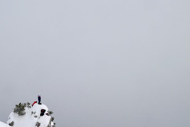 A coach stands on the top of a peak to watch the official training for the women's downhill event during the Milano Cortina 2026 Winter Olympic Games at the Tofane Alpine Skiing Centre in Cortina d’Ampezzo on February 7, 2026. (Photo by Stefano RELLANDINI / AFP)