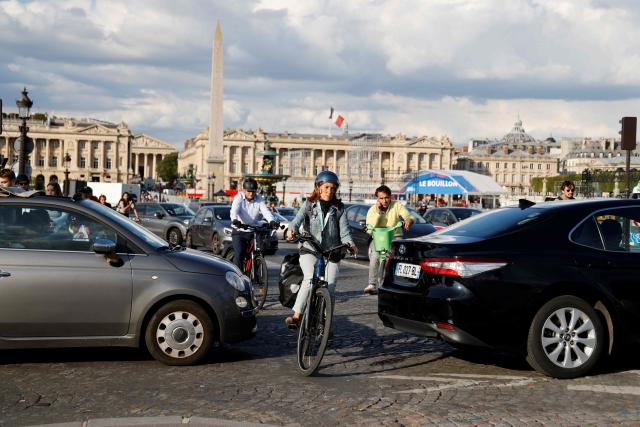 (FILES) People ride bicycles on Place de la Concorde in Paris on August 28, 2023. The candidates for mayor of Paris, with the exception of the far right, set out their commitments on February 6, 2026 before various associations regarding the future of cycling in the capital, where this mode of transport has surged under Anne Hidalgo’s tenure. (Photo by Ludovic MARIN / AFP)