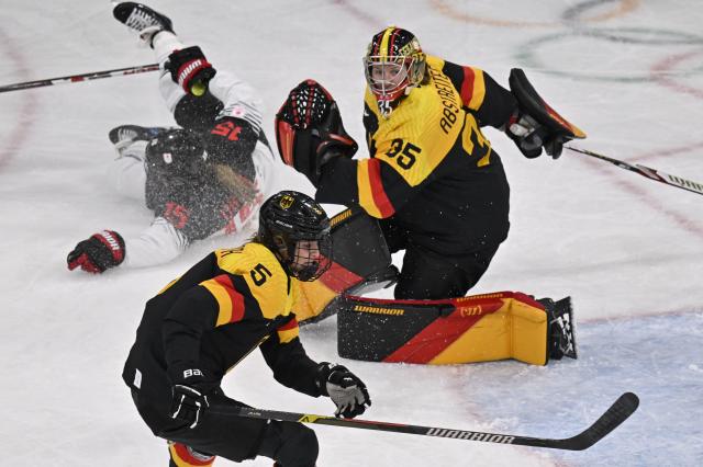 Germany's goalkeeper #35 Sandra Abstreiter looks on as Germany's defender #05 Charlott Schaffrath vies for the puck during the women's preliminary round Group B Ice Hockey match between Germany and Japan at the Milano Rho Ice Hockey Arena at the Milano Cortina 2026 Winter Olympic Games in Milan, on February 7, 2026. (Photo by Alexander NEMENOV / AFP)