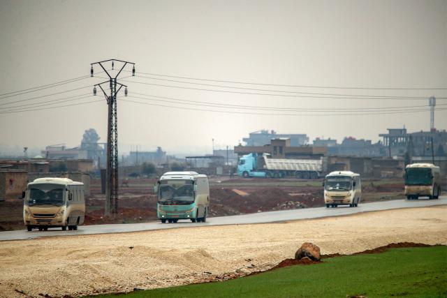 Buses in a US military convoy transporting Islamic State group detainees being transferred to Iraq from Syria move along a road on the outskirts of Qahtaniyah in Syria's northeastern Hasakah province on February 7, 2026. Iraq's judiciary announced on February 2 that it had begun investigations into more than 1,300 Islamic State group detainees who were transferred from Syria as part of a US operation. (Photo by Delil SOULEIMAN / AFP)