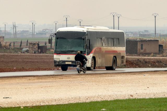 A bus in a US military convoy transporting Islamic State group detainees being transferred to Iraq from Syria moves along a road on the outskirts of Qahtaniyah in Syria's northeastern Hasakah province on February 7, 2026. Iraq's judiciary announced on February 2 that it had begun investigations into more than 1,300 Islamic State group detainees who were transferred from Syria as part of a US operation. (Photo by Delil SOULEIMAN / AFP)