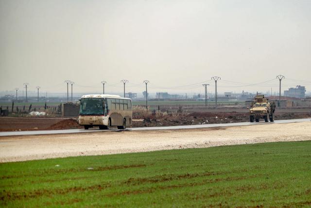 A bus in a US military convoy transporting Islamic State group detainees being transferred to Iraq from Syria moves along a road on the outskirts of Qahtaniyah in Syria's northeastern Hasakah province on February 7, 2026. Iraq's judiciary announced on February 2 that it had begun investigations into more than 1,300 Islamic State group detainees who were transferred from Syria as part of a US operation. (Photo by Delil SOULEIMAN / AFP)
