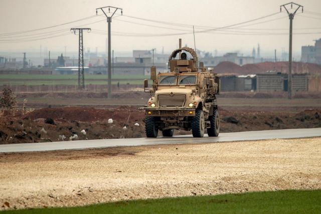 A US military mine-resistant ambush protected (MRAP) armoured fighting vehicle moves along a road in a convoy transporting Islamic State group detainees being transferred to Iraq from Syria, on the outskirts of Qahtaniyah in Syria's northeastern Hasakah province on February 7, 2026. Iraq's judiciary announced on February 2 that it had begun investigations into more than 1,300 Islamic State group detainees who were transferred from Syria as part of a US operation. (Photo by Delil SOULEIMAN / AFP)