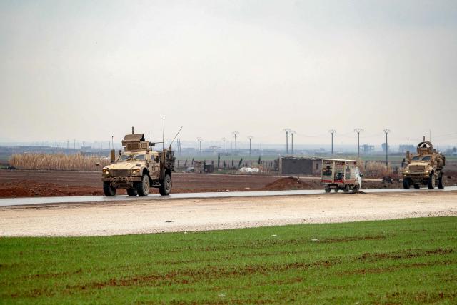 US military vehicles move along a road in a convoy transporting Islamic State group detainees being transferred to Iraq from Syria, on the outskirts of Qahtaniyah in Syria's northeastern Hasakah province on February 7, 2026. Iraq's judiciary announced on February 2 that it had begun investigations into more than 1,300 Islamic State group detainees who were transferred from Syria as part of a US operation. (Photo by Delil SOULEIMAN / AFP)