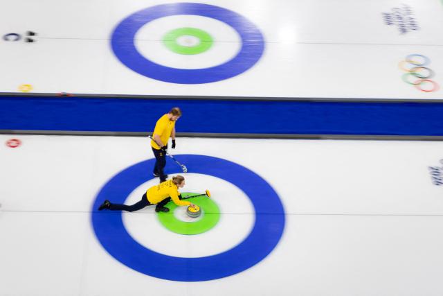 Sweden's Isabella Wranaa (below) and Sweden's Rasmus Wranaa compete (above) in in the curling mixed doubles round robin between Switzerland and Sweden during the Milano Cortina 2026 Winter Olympic Games at the Cortina Curling Olympic Stadium in Cortina d’Ampezzo on February 7, 2026. (Photo by Odd ANDERSEN / AFP)