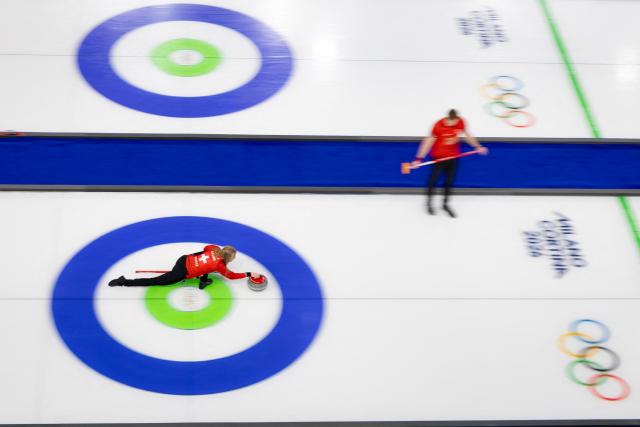 Switzerland's Briar Schwaller-Huerlimann (L) and Switzerland's Yannick Schwaller (R) compete in the curling mixed doubles round robin between Switzerland and Sweden during the Milano Cortina 2026 Winter Olympic Games at the Cortina Curling Olympic Stadium in Cortina d’Ampezzo on February 7, 2026. (Photo by Odd ANDERSEN / AFP)