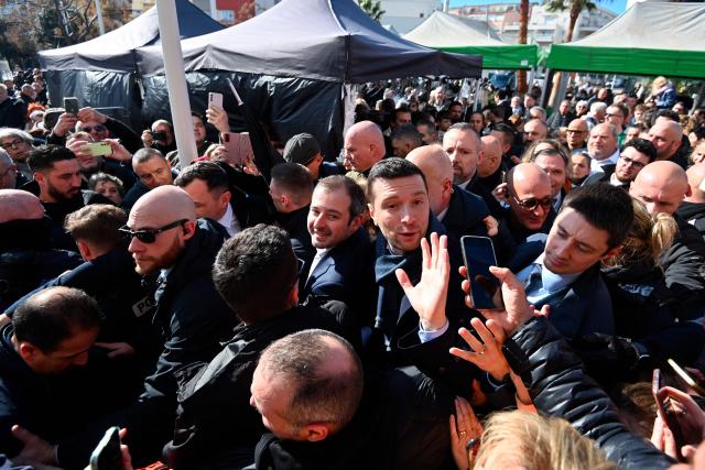President of French far-right Rassemblement National (RN) party and Member of the European Parliament Jordan Bardella (C-R) arrives at the Cap d'Agde market in support of Aurélien Lopez-Liguori, lead candidate in the Agde municipal elections, in Cap d'Agde, southern France on February 7, 2026. (Photo by Sylvain THOMAS / AFP)