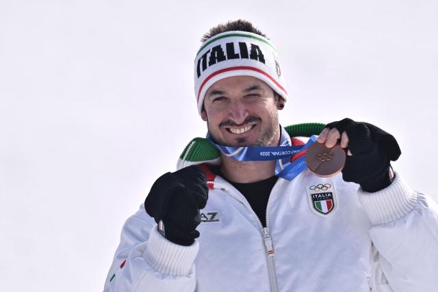 Bronze medallist Italy's Dominik Paris poses  on the podium of the men's downhill alpine skiing event during the Milano Cortina 2026 Winter Olympic Games at the Stelvio Ski Centre in Bormio (Valtellina) on February 7, 2026. (Photo by Jeff PACHOUD / AFP)