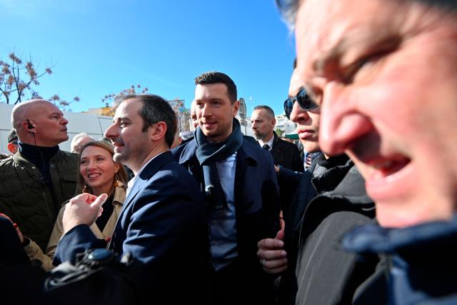 The president of French far-right Rassemblement National (RN) party and Member of the European Parliament (MEP) Jordan Bardella (C) arrives at the Cap d'Agde market, southern France, during a visit in support of Aurélien Lopez-Liguori (C-L), lead candidate in the Agde municipal elections, on February 7, 2026. (Photo by Sylvain THOMAS / AFP)