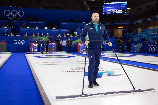 An official sweeps the ice during the curling mixed doubles round robin between Britain and Canada during the Milano Cortina 2026 Winter Olympic Games at the Cortina Curling Olympic Stadium in Cortina d’Ampezzo on February 7, 2026. (Photo by Odd ANDERSEN / AFP)