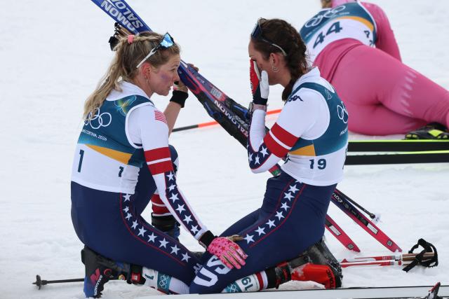 USA's Jessie Diggins (L) and Germany's Pia Fink react after crossing the finish line of the women's cross country 10km + 10km skiathlon event of the Milano Cortina 2026 Winter Olympic Games at Tesero Cross-Country Skiing Stadium in Lago di Tesero (Val di Fiemme) on February 7, 2026. (Photo by Anne-Christine POUJOULAT / AFP)