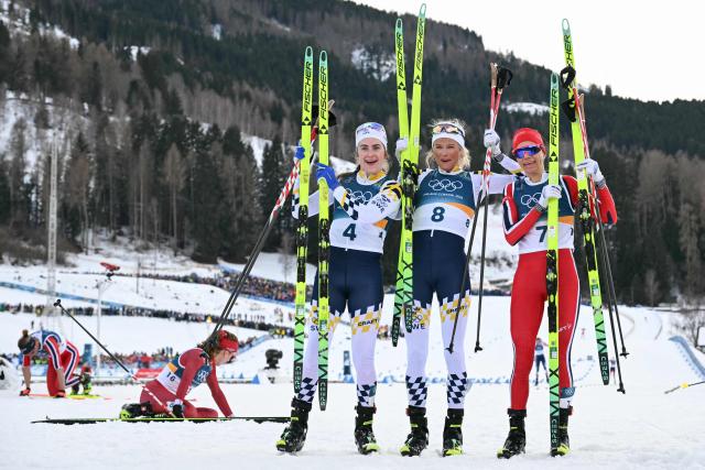 (From L) Silver medallist Sweden's Ebba Andersson, gold medallist Sweden's Frida Karlsson and bronze medallist Norway's Heidi Weng celebrate after the women's cross country 10km + 10km skiathlon event of the Milano Cortina 2026 Winter Olympics at Tesero Cross-Country Skiing Stadium in Lago di Tesero (Val di Fiemme) on February 7, 2026. (Photo by Javier SORIANO / AFP)