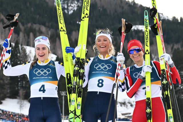 (From L) Silver medallist Sweden's Ebba Andersson, gold medallist Sweden's Frida Karlsson and bronze medallist Norway's Heidi Weng celebrate after the women's cross country 10km + 10km skiathlon event of the Milano Cortina 2026 Winter Olympics at Tesero Cross-Country Skiing Stadium in Lago di Tesero (Val di Fiemme) on February 7, 2026. (Photo by Javier SORIANO / AFP)