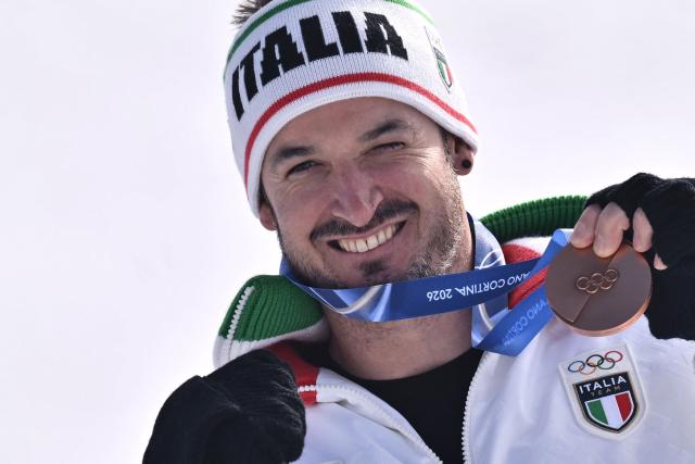 Bronze medallist Italy's Dominik Paris poses  on the podium of the men's downhill alpine skiing event during the Milano Cortina 2026 Winter Olympic Games at the Stelvio Ski Centre in Bormio (Valtellina) on February 7, 2026. (Photo by Jeff PACHOUD / AFP)