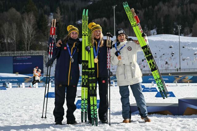 (From L) Silver medallist Sweden's Ebba Andersson, gold medallist Sweden's Frida Karlsson and bronze medallist Norway's Heidi Weng celebrate on the podium for the women's cross country 10km + 10km skiathlon event of the Milano Cortina 2026 Winter Olympics at Tesero Cross-Country Skiing Stadium in Lago di Tesero (Val di Fiemme) on February 7, 2026. (Photo by Javier SORIANO / AFP)