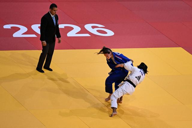 France's Chole Devictor (C) competes against France's Sarah Leonie Cysique (R) during the women's -57kg Semi-Final at the Paris Grand Slam judo tournament in Paris on February 7, 2026. (Photo by Julie SEBADELHA / AFP)