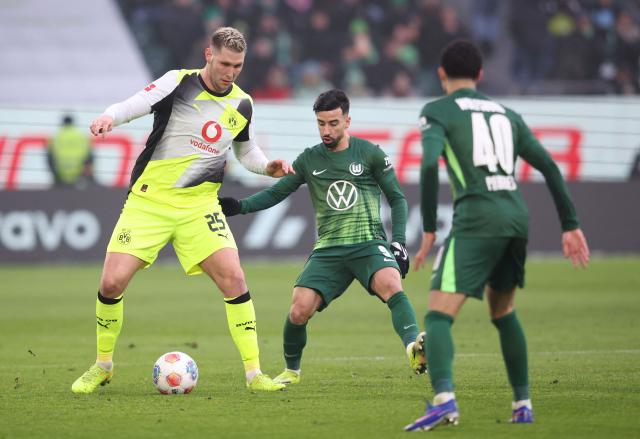 Dortmund's German defender #25 Niklas Suele (L) and Wolfsburg's Algerian forward #09 Mohammed Amoura vie for the ball during the German first division Bundesliga football match between VfL Wolfsburg and Borussia Dortmund in Wolfsburg, on February 7, 2026. (Photo by Ronny HARTMANN / AFP) / DFL REGULATIONS PROHIBIT ANY USE OF PHOTOGRAPHS AS IMAGE SEQUENCES AND/OR QUASI-VIDEO
