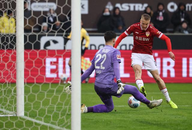 Stuttgart's German midfielder #10 Chris Fuehrich (R) misses to score past St Pauli's Bosnian goalkeeper #22 Nikola Vasilj during the German first division Bundesliga football match between St Pauli and VfB Stuttgart in Hamburg, northern Germany, on February 7, 2026. (Photo by Ibrahim OT / AFP) / DFL REGULATIONS PROHIBIT ANY USE OF PHOTOGRAPHS AS IMAGE SEQUENCES AND/OR QUASI-VIDEO