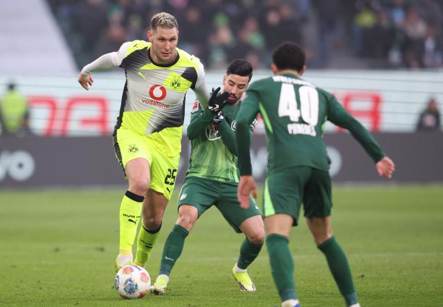 Dortmund's German defender #25 Niklas Suele (L) and Wolfsburg's Algerian forward #09 Mohammed Amoura vie for the ball during the German first division Bundesliga football match between VfL Wolfsburg and Borussia Dortmund in Wolfsburg, on February 7, 2026. (Photo by Ronny HARTMANN / AFP) / DFL REGULATIONS PROHIBIT ANY USE OF PHOTOGRAPHS AS IMAGE SEQUENCES AND/OR QUASI-VIDEO