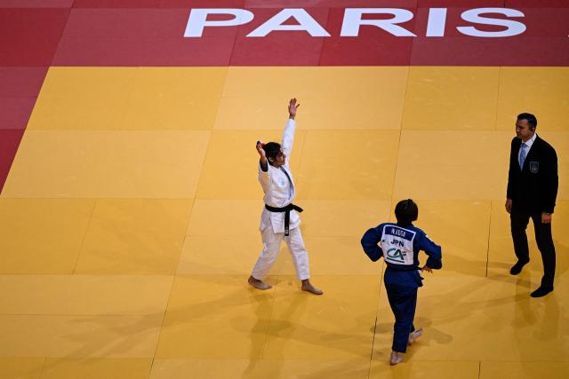 France's Shirine Boukli (L) celebrates after winning against Japan's Wakane Koga (C) the women's -48kg Semi-Final at the Paris Grand Slam judo tournament in Paris on February 7, 2026. (Photo by Julie SEBADELHA / AFP)