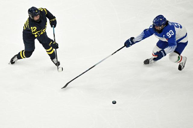 Italy's #93 Nadia Mattivi (R) and Sweden's #12 Maja Nylen Persson vie for the puck during the women's preliminary round Group B Ice Hockey match between Sweden and Italy at the Milano Santagiulia Ice Hockey Arena at the Milano Cortina 2026 Winter Olympic Games in Milan, on February 7, 2026. (Photo by JULIEN DE ROSA / AFP)