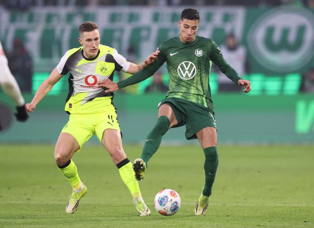 Dortmund's German defender #04 Nico Schlotterbeck (L) and Wolfsburg's Danish-Palestinians forward #11 Adam Daghim vie for the ball during the German first division Bundesliga football match between VfL Wolfsburg and Borussia Dortmund in Wolfsburg, on February 7, 2026. (Photo by Ronny HARTMANN / AFP) / DFL REGULATIONS PROHIBIT ANY USE OF PHOTOGRAPHS AS IMAGE SEQUENCES AND/OR QUASI-VIDEO