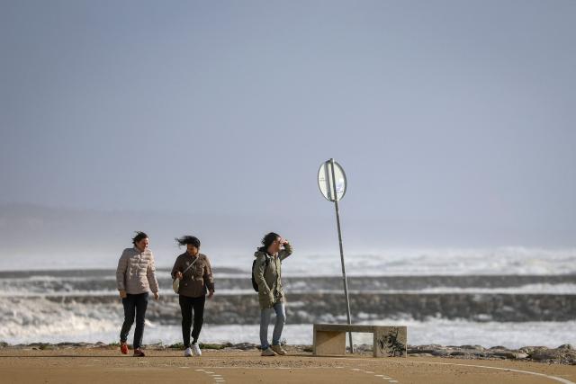 People walk along the promenade as Storm Marta whips up a rough sea in Costa da Caparica, Portugal, on February 7, 2026. Spain and Portugal today faced fresh storms and torrential rain just days after floods caused by Storm Leonardo proved fatal in both countries and caused significant damage. In Portugal, the latest depression -- christened Storm Marta -- has prompted the deployment of more than 26,500 rescuers and led three municipalities to postpone by a week a presidential vote meant to be held tomorrow. (Photo by PATRICIA DE MELO MOREIRA / AFP)