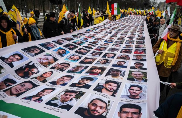 Protesters display a banner featuring portraits of alleged victims of the Iranian government during a demonstration called for by supporters of Maryam Rajavi, leader of the People's Mujahedin of Iran (MEK), against the Iranian government, in Berlin on February 7, 2026. (Photo by John MACDOUGALL / AFP)