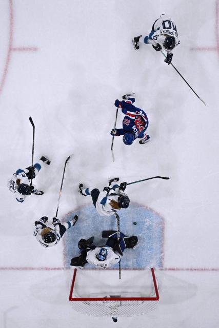 US' forward #22 Tessa Janecke (2nd R) shoots to goal  during the women's preliminary round Group A Ice Hockey match between USA and Finland at the Milano Rho Ice Hockey Arena at the Milano Cortina 2026 Winter Olympic Games in Milan, on February 7, 2026. (Photo by Alexander NEMENOV / AFP)