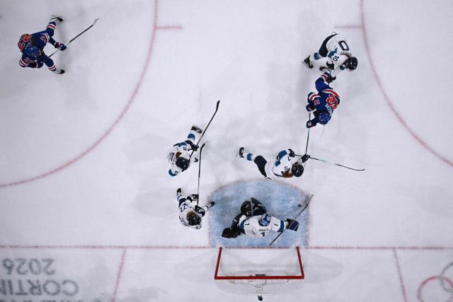 US' forward #22 Tessa Janecke (2nd R) shoots to goal  during the women's preliminary round Group A Ice Hockey match between USA and Finland at the Milano Rho Ice Hockey Arena at the Milano Cortina 2026 Winter Olympic Games in Milan, on February 7, 2026. (Photo by Alexander NEMENOV / AFP)