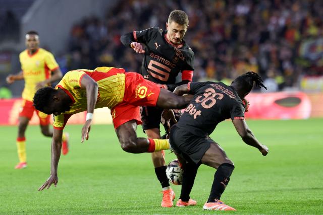 Lens' French forward #11 Odsonne Edouard (L) fights for the ball with Rennes' French midfielder #21 Valentin Rongier (C) during the French L1 football match between RC Lens and Stade Rennais FC at the Stade Bollaert-Delelis in Lens, northern France on February 7, 2026. (Photo by Francois LO PRESTI / AFP)