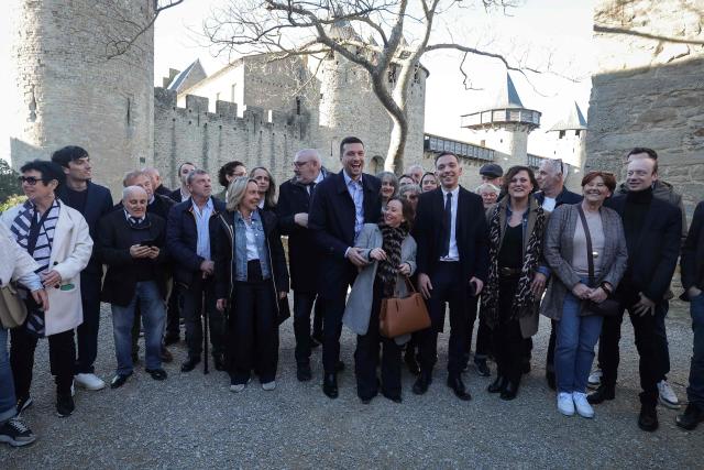 President of French far-right Rassemblement National (RN) party and Member of the European Parliament Jordan Bardella (C) poses with RN candidate for Mayor of Carcassonne, Christophe Barthes (CL), in Carcassonne, south-western France, on February 7, 2026. (Photo by Valentine CHAPUIS / AFP)