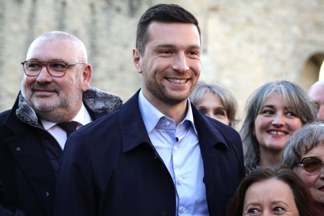 President of French far-right Rassemblement National (RN) party and Member of the European Parliament Jordan Bardella (C) poses with RN candidate for Mayor of Carcassonne, Christophe Barthes (L), in Carcassonne, south-western France, on February 7, 2026. (Photo by Valentine CHAPUIS / AFP)