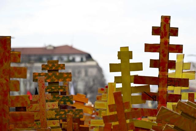 Demonstrators hold up cardboard trees representing the larch trees cut to build the new sliding center in Cortina d'Ampezzo during a demonstration against the environmental, economic and social impact of the Milano-Cortina 2026 Winter Olympics Games, in Milan on February 7, 2026. (Photo by PIERO CRUCIATTI / AFP)
