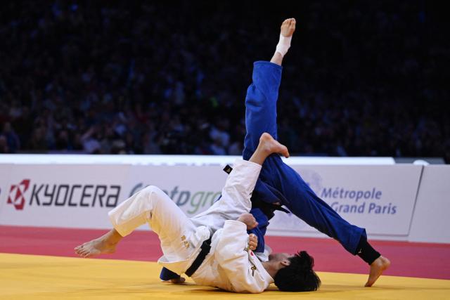 TOPSHOT - Japan's Takeshi Takeoka (in white) competes against South Korea's Channyeong Kim in the men's -66kg Final bout at the Paris Grand Slam judo tournament in Paris on February 7, 2026. (Photo by Julie SEBADELHA / AFP)