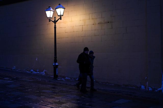 People walk on a street in central Moscow on February 7, 2026. (Photo by HECTOR RETAMAL / AFP)