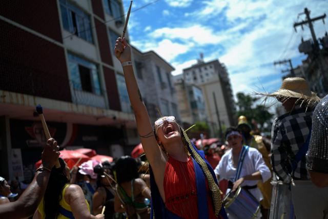 A reveler wearing a costume paying tribute to the Brazilian movie A Dog’s Will reacts during the parade of the street carnival group Butano na Bureta in the streets of Maracana neighborhood, north zone of Rio de Janeiro, Brazil on February 7, 2026. The street carnival group pays tribute to Brazilian cinema past and present, with a special dedication to the recent worldwide hits ‘The Secret Agent’ and ‘I’m Still Here’. (Photo by Mauro PIMENTEL / AFP)