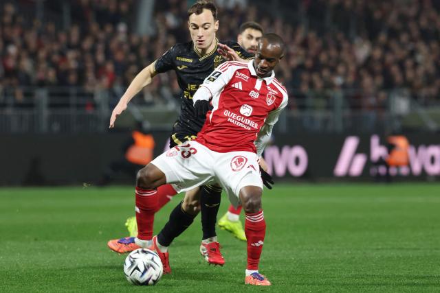 Brest's Malian midfielder #23 Kamory Doumbia (front) and Lorient's French forward #10 Pablo Pagis (back) fight for the ball during the French L1 football match between Stade Brestois 29 (Brest) and FC Lorient at the Stade Francis-Le-Ble in Brest, western France, on February 7, 2026. (Photo by Fred TANNEAU / AFP)